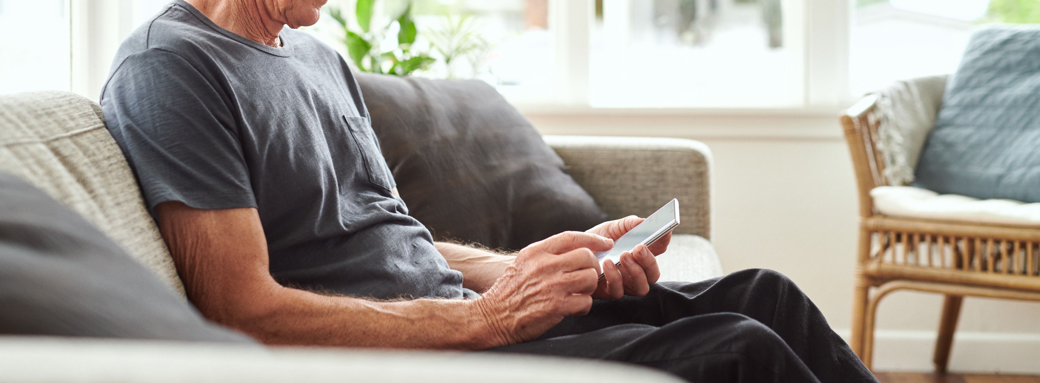 man on his couch look at a phone